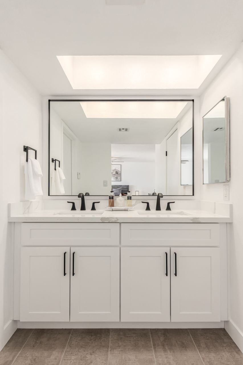 Double vanity bathroom with wood-look tile floor
