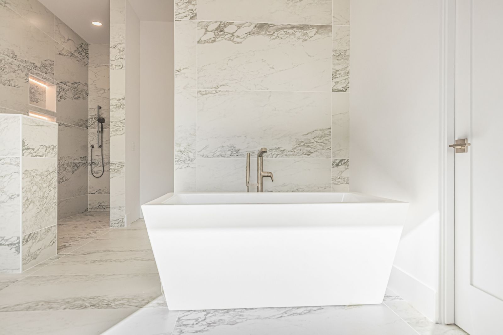Freestanding tub with marble-look porcelain walls and floor