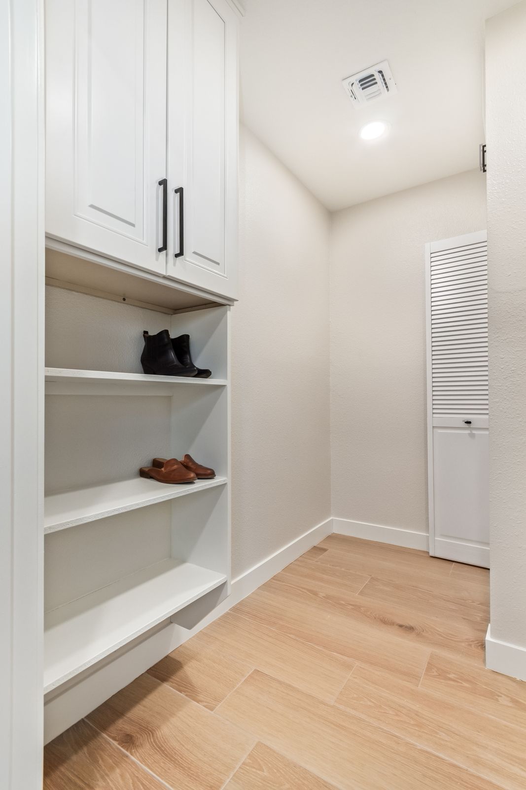 Built-in shelving over wood-look plank flooring