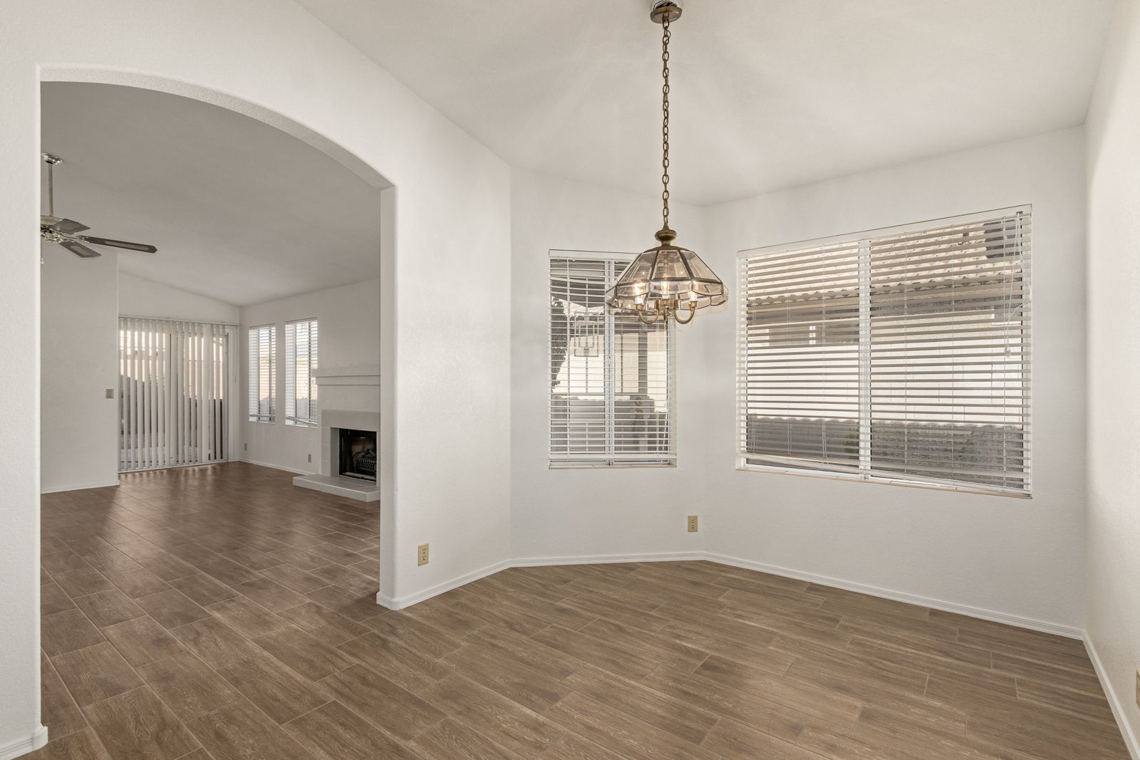 Dining room with wood-look tile under an arched opening