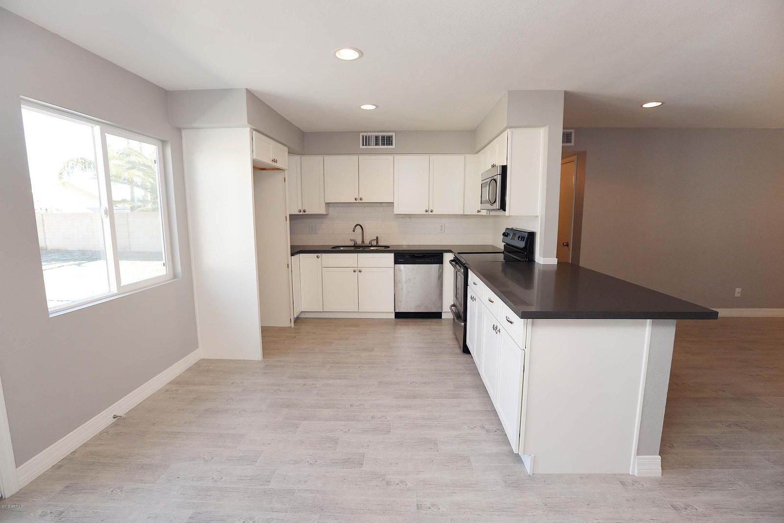 Open-plan kitchen with continuous tile flooring
