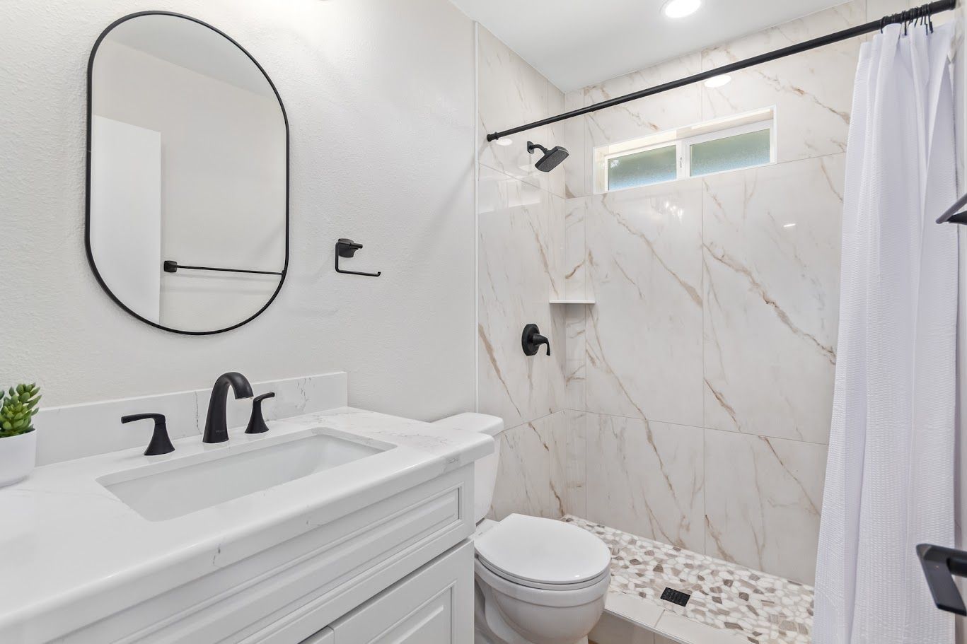 Marble-look tile shower in a casita bathroom