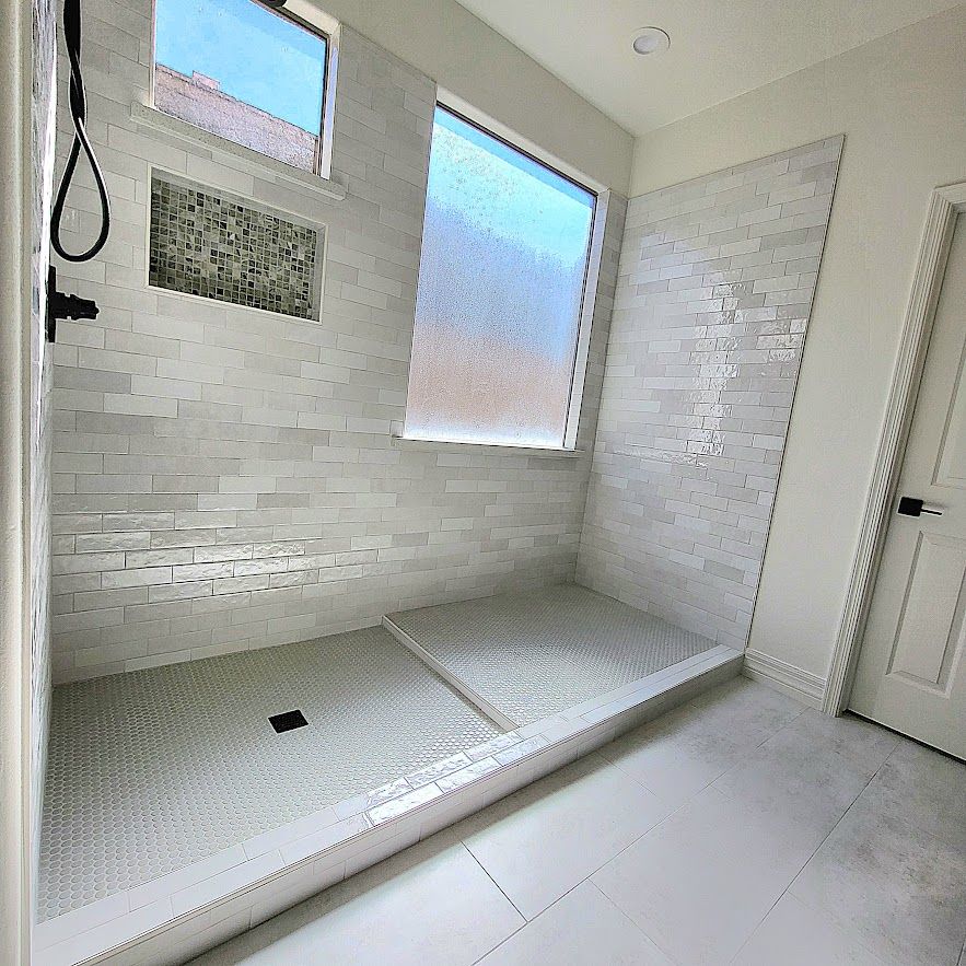 Walk-in shower with mosaic floor and recessed niche